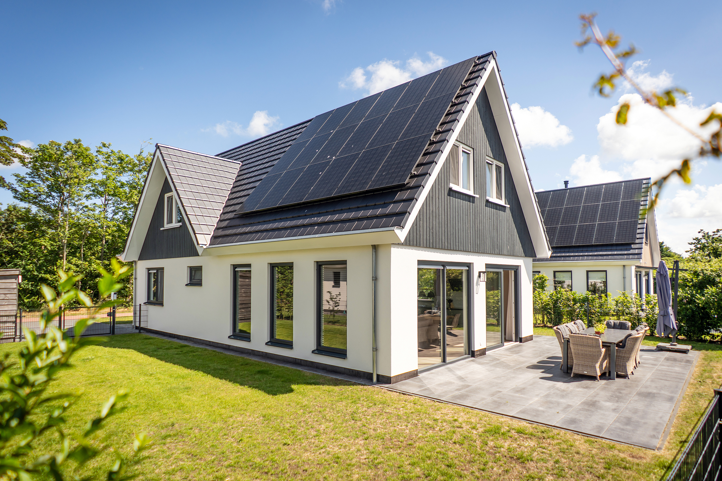 Achterzijde en terras van Villa 21 met omheinde tuin op Texel