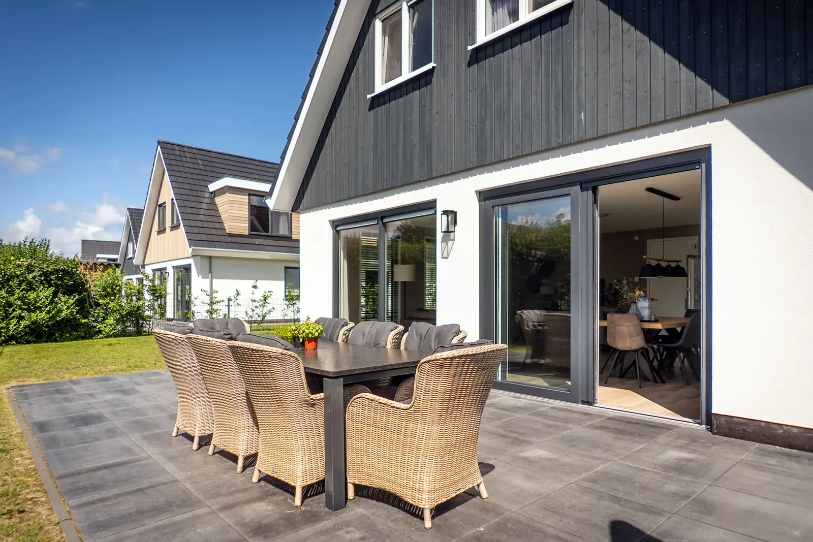 Terras met tuinset en schuifpui naar de woonkamer van Villa 21 op Texel